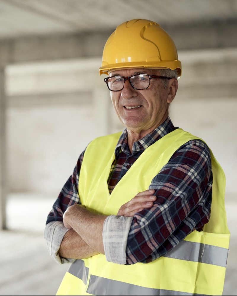 Senior caucasian man holding plans on the construction site